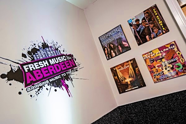 Studio wall painted with the Fresh Music Aberdeen Bringing Music to the City logo, next to framed vinyl record covers by Deep Purple, The Animals, Status Quo and Art of Atlantic